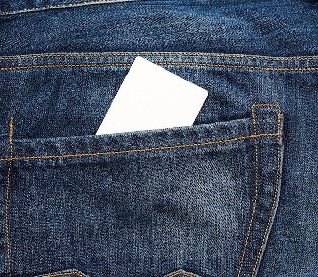 La tarjeta de papel blanco vacía está en el bolsillo trasero de los pantalones vaqueros azules