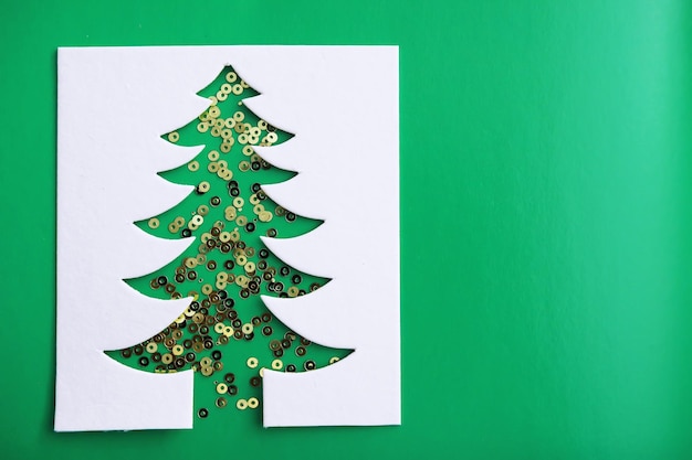 Foto tarjeta de papercraft de diseño de corte de papel de árbol de navidad. color blanco, rojo y verde