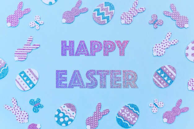 Foto tarjeta de pascua feliz brillo decorativo huevos de pascua púrpura y conejitos sobre un fondo azul texto degradado brillante feliz pascua hecho en colores de moda