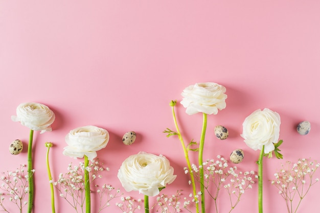 Tarjeta de pascua feliz con las flores blancas en fondo rosado