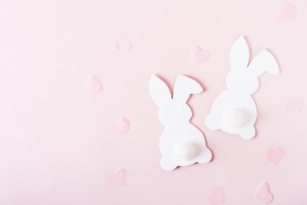 Tarjeta de pascua feliz pareja conejos blancos y corazones en la vista superior rosa
