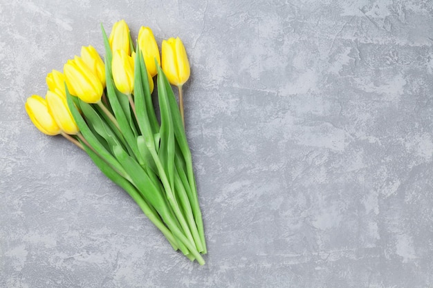 Tarjeta de Pascua fondo de piedra con tulipanes amarillos