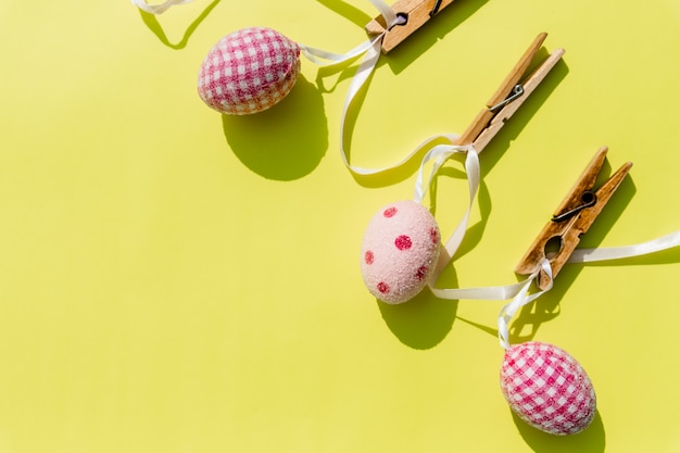 Tarjeta de Pascua y huevos colgando en el tendedero