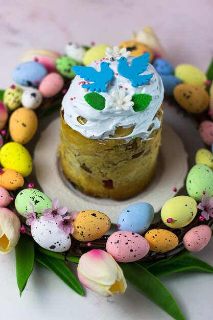 Tarjeta de Pascua Kulich con dulce de azúcar en una corona de tulipanes y huevos Dulce de malvavisco con decoración Orientación vertical