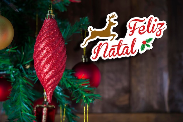 Foto tarjeta postal de felicitación de navidad que muestra un adorno rojo de navidad y un espacio de copia lleno de arte de texto escrito en portugués 