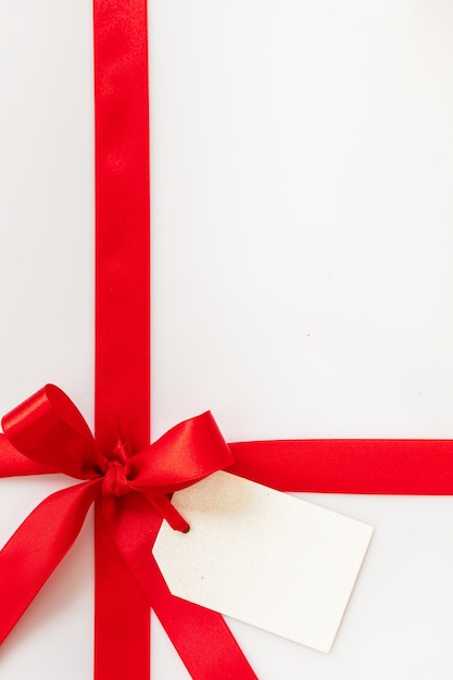 Tarjeta de regalo de Navidad en blanco y lazo rojo en fondo blanco concepto de regalo de año nuevo