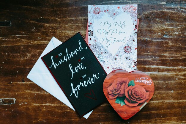 Una tarjeta de San Valentín y chocolate en la mesa de madera Foto de stock