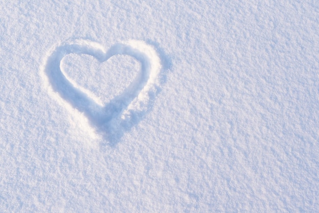 Tarjeta de San Valentín con un corazón en la nieve y espacio para copiar