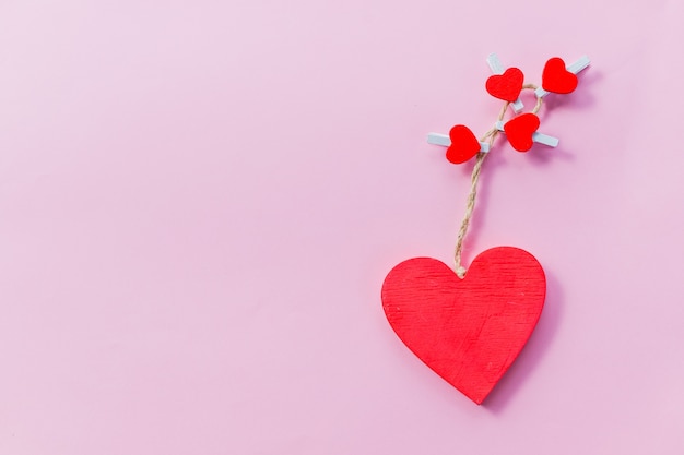 Tarjeta de San Valentín Corazones rojos de madera aislados sobre fondo rosa concepto de feliz día de San Valentín. Postal festiva Concepto de amor para el día de la madre y el día de san valentín.