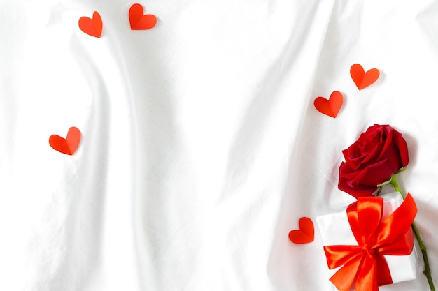 Tarjeta de vacaciones vista superior corazones de papel rosa roja y caja con regalo en la cama blanca Fondo de San Valentín Feliz día de la madre Feliz día de la mujer Feliz cumpleaños Buenos días Propuesta de matrimonio