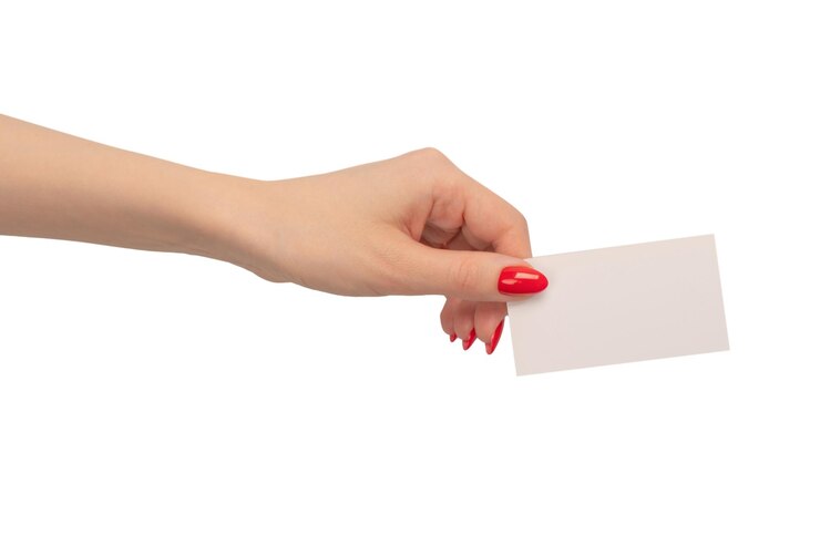 Foto tarjeta vacía en mano de mujer con uñas rojas aisladas en un fondo blanco