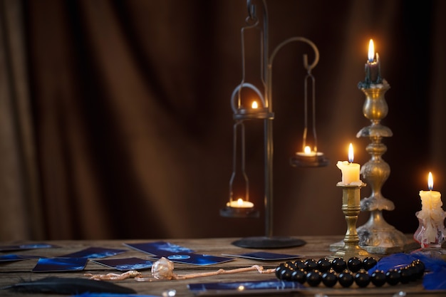 Tarjetas de adivinación y velas encendidas en una mesa de madera
