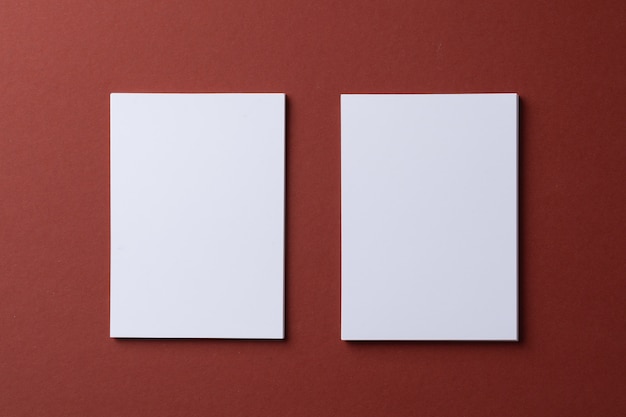 Foto tarjetas blancas en blanco sobre fondo de papel burdeos