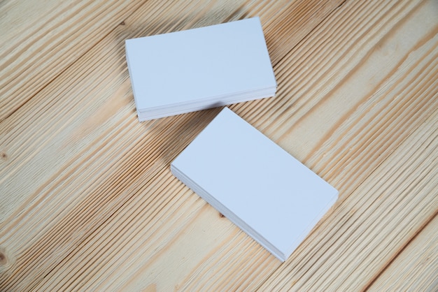 Foto tarjetas en blanco en mesa de trabajo de madera