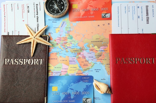 Tarjetas de crédito con pasaportes y boletos para vacaciones en el fondo del mapa mundial