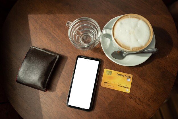 Las tarjetas de crédito y el teléfono se colocan sobre una mesa de madera en la cafetería.