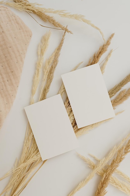 Foto tarjetas de hoja de papel en blanco con espacio de copia de maqueta hierba de pampa seca sobre fondo blanco plantilla de marca comercial mínima de vista plana superior