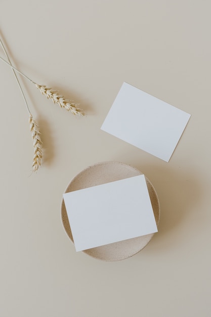 Tarjetas de papel en blanco con tallos de centeno de trigo en beige