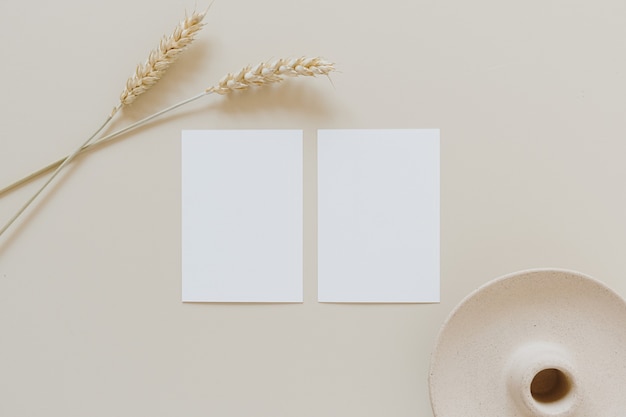 Tarjetas de papel en blanco con tallos de centeno de trigo en beige