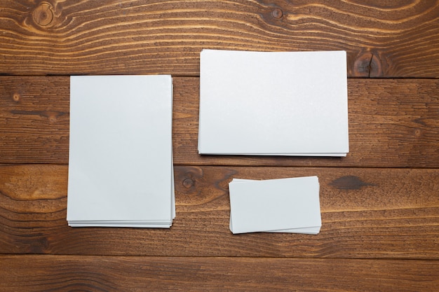 Tarjetas de visita blancas en blanco en la mesa de madera