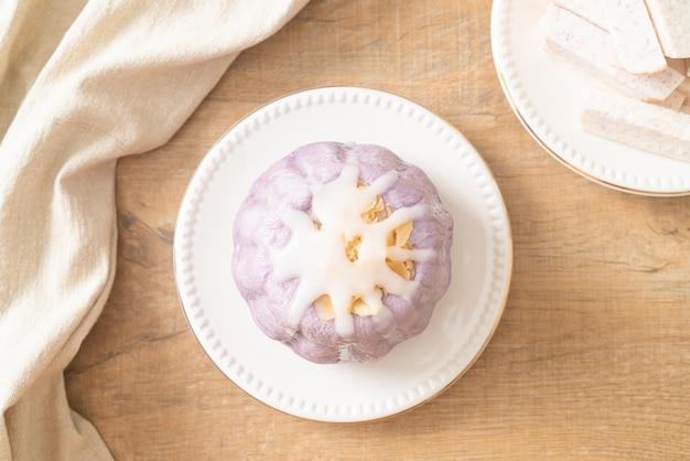 Tarobrötchen mit weißer Zuckercreme und Nuss darauf