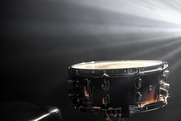Tarola no fundo de um instrumento de percussão de holofotes no escuro com a fumaça do palco