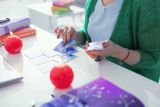 Tarotkarten in Wahrsagerei. Draufsicht auf Tarotkarten, die während einer professionellen Wahrsagerin auf den Tisch gelegt werden