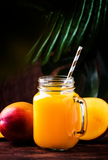 Tarro de batido de mango con fruta fresca sobre fondo de madera rústica espacio de copia concepto de bebida de verano