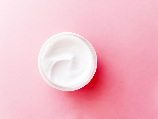 Tarro de crema facial sobre fondo rosa belleza cuidado de la piel y producto cosmético