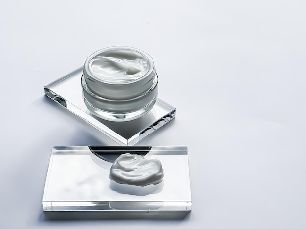 Tarro de crema hidratante para la cara y muestra de producto en vidrio belleza y ciencia cosmética para el cuidado de la piel