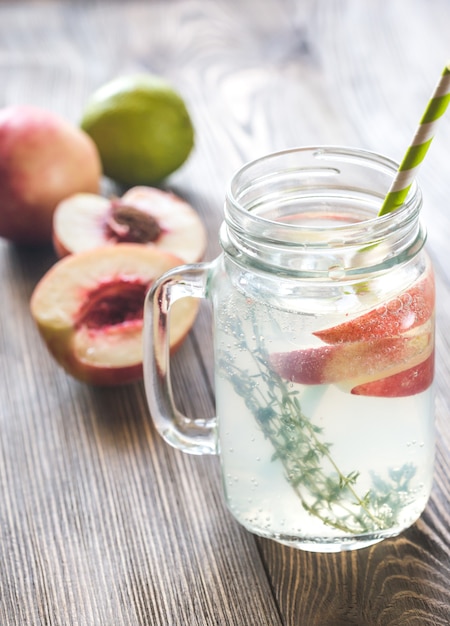 Tarro de cristal de agua de lima con rodajas de durazno