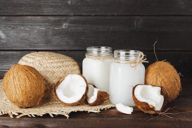 Tarro de cristal de leche de coco de cerca sobre la superficie de madera