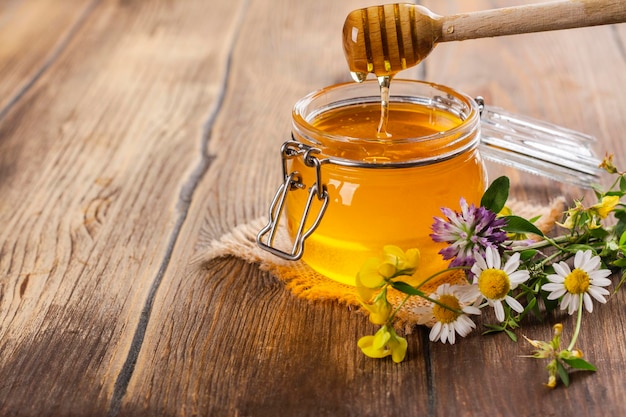 Tarro de cristal con miel líquida floral.