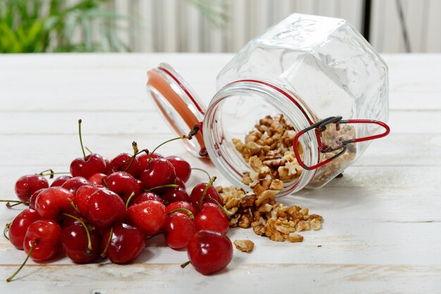 Tarro de cristal con nueces peladas y cerezas