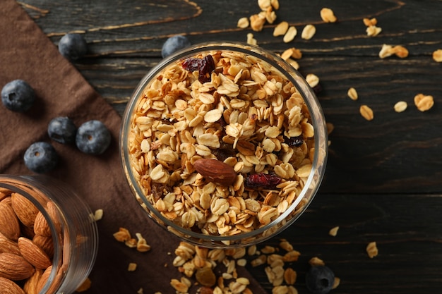 Tarro de cristal con sabrosa granola en mesa de madera