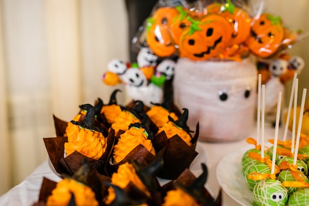 Tarro grande decorado con malvaviscos de calabaza en la barra de chocolate para la celebración de Halloween