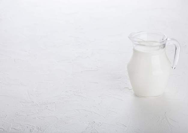 Foto tarro de leche en la mesa de la cocina de piedra blanca.