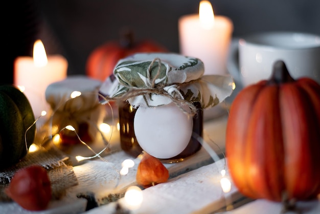 Tarro de mermelada en decoración de otoño con calabaza y taza de té Fondo blanco