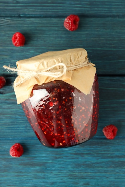 Foto tarro de mermelada de frambuesa con ingredientes sobre fondo de madera