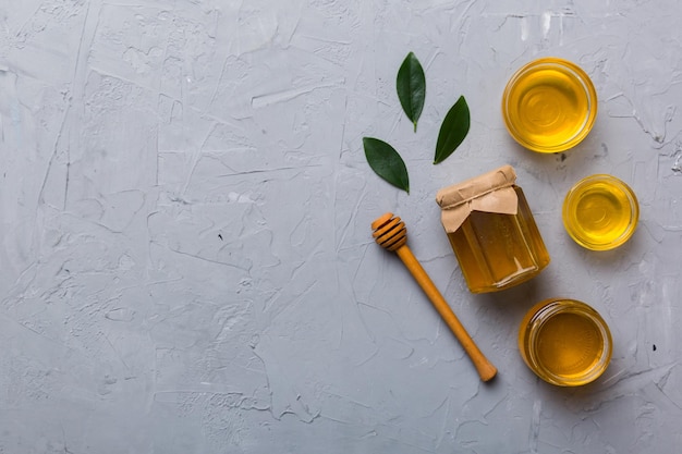 Tarro de miel con cucharón de miel de madera sobre fondo blanco vista superior con espacio de copia Botella de miel deliciosa