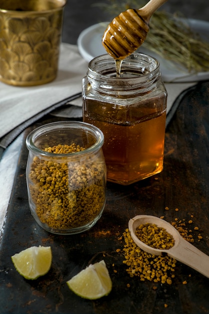 Foto tarro de miel drenante, tarro de polen, limón y hierbas para el té.