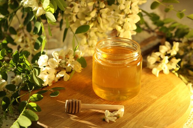 tarro de miel con flor de flores blancas