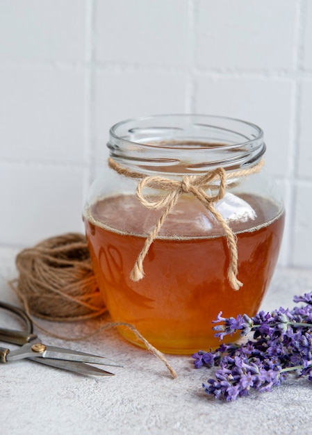 Tarro con miel y flores frescas de lavanda sobre un fondo de hormigón