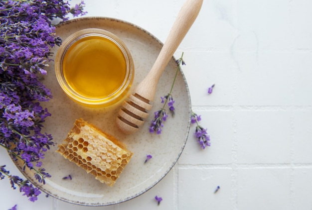 Tarro con miel y flores frescas de lavanda.