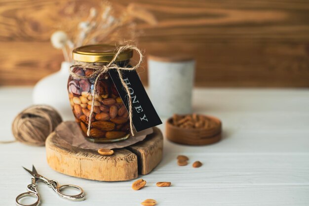 Un tarro de miel con nueces está sobre la mesa Alimentos orgánicos saludablesUn tarro de miel con nueces está en la pestaña