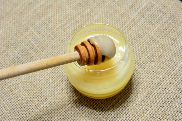 tarro con miel de tilo aislado sobre fondo de arpillera