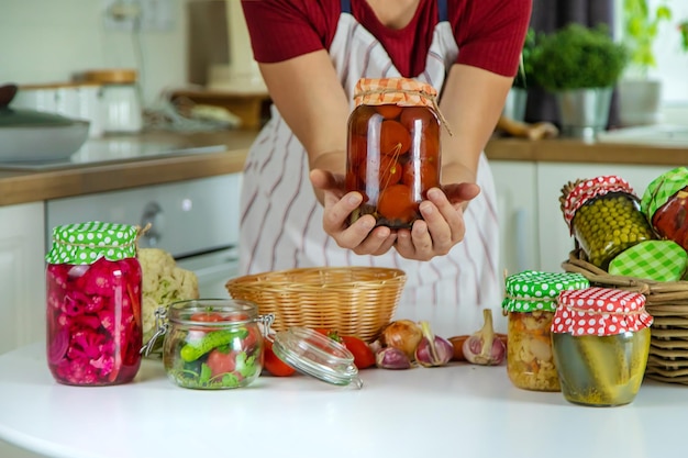 Tarro de mujer conserva verduras en la cocina Enfoque selectivo