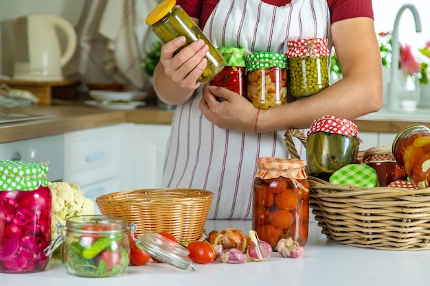 Tarro de mujer conserva verduras en la cocina Enfoque selectivo