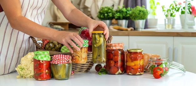 Tarro de mujer conserva verduras en la cocina Enfoque selectivo