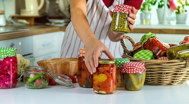 Tarro de mujer conserva verduras en la cocina Enfoque selectivo